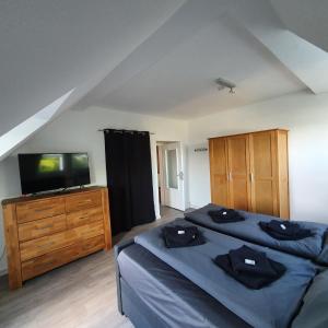 a bedroom with two beds and a flat screen tv at Ferienwohnung Fernblick in Remscheid +28 photos