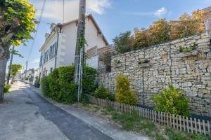 Un muro de piedra junto a un edificio con una valla en Kawaii - Domaine Tropical, en Saint-Aignan