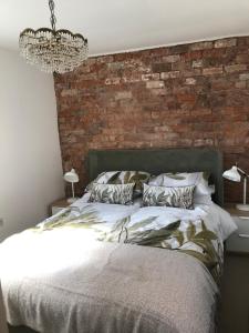 a bedroom with a brick wall and a bed at Clerks Cottage in Upton upon Severn