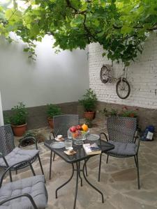 un tavolo con sedie e un cesto di frutta. di Green Housee a Korçë