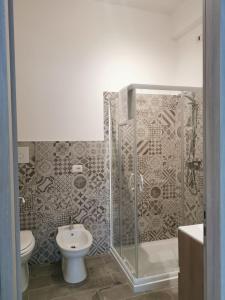 een badkamer met een douche, een toilet en een wastafel bij Al Cortile in Reggio di Calabria