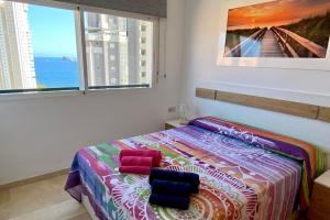 1 dormitorio con 1 cama con 2 almohadas en See the Sea Miramar apartment - 150m to the beach en Benidorm