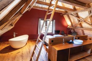 um quarto loft com uma escada e uma banheira em Hotel Schloss Rued - Boutique Hideaway em Schlossrued