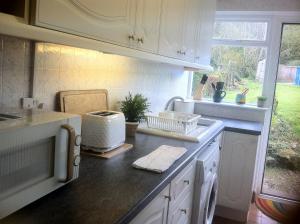 a kitchen with white cabinets and a counter with a toaster at Charming cottage within farmhouse in Monmouth