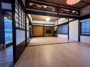 Habitación grande con suelo y ventanas de madera. en ドッグラン併設 しまなみ御殿, en Imabari