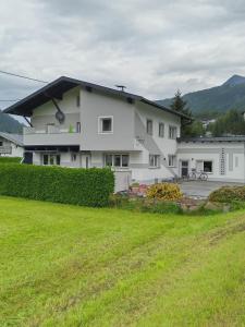 a large white house with a grass yard at Haus Fini in Längenfeld