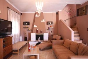 a living room with a couch and a staircase at Alice Maisonette & Studios in Adamantas