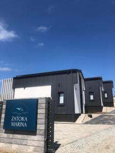 a building with a sign in front of it at Zatoka Marina in Mechelinki