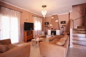 a living room with two couches and a tv at Alice Maisonette & Studios in Adamantas