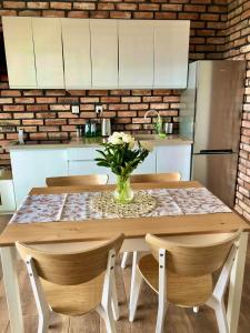a kitchen with a table with a vase of flowers on it at Zatoka Marina in Mechelinki