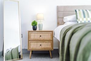 a bedroom with a bed and a night stand with a lamp at Woodyear Road in Bromborough