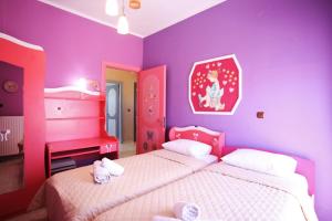 a purple bedroom with two beds and a desk at Alice Maisonette & Studios in Adamantas