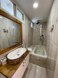 a bathroom with a tub and a sink and a bath tub at Diamond Luxury Apartment - Haifa in Haifa +85 photos