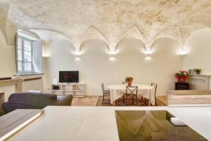a living room with a table and a tv at Il Loft di Quintino in Parma