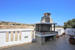a stone oven on a patio with a view of the ocean at Alice Maisonette & Studios in Adamantas