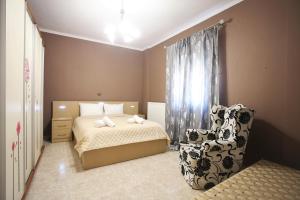 a bedroom with a bed and a chair at Alice Maisonette & Studios in Adamantas