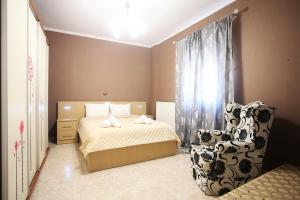a bedroom with a bed and a chair at Alice Maisonette & Studios in Adamantas
