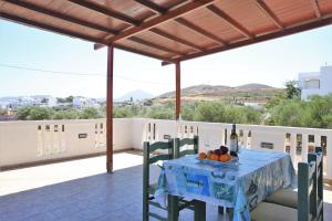 a table with a bottle of wine and fruit on a balcony at Alice Maisonette & Studios in Adamantas