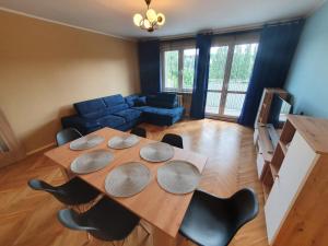 un soggiorno con tavolo e sedie in legno di Cozy Sunny Apartment a Gdynia