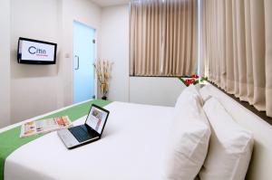 فندق سيتين مسجد جاميك باي كومباس هوسبيتاليتي في كوالالمبور: غرفة في الفندق مع لاب توب على سرير