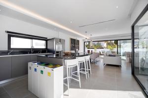 an open kitchen with a bar and a dining room at Andrea Sea Villa in Novo Sancti Petri