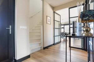 a hallway with a staircase and a table in a house at New high end waterfront family villa in Stavoren