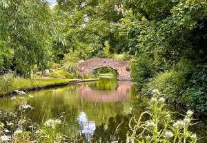 een brug over een rivier in een tuin bij The Hyde Dovecote, Kinver in Stourbridge