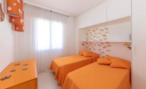 Magnifico appartamento Dominique Jesolo Lido Carraro Immobiliare - Family Apartments tesisinde bir odada yatak veya yataklar