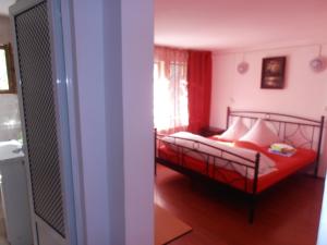 a bedroom with a bed with red sheets and a window at Pensiunea Sans Rival in Iaşi