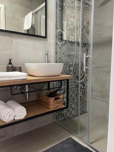 La salle de bains est pourvue d'un lavabo et d'une douche. dans l'établissement Apartments CLIFF Piran, à Piran