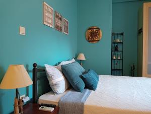 a bedroom with blue walls and a bed with pillows at Amelie's Apartments in Mesolongion