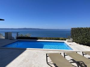 a swimming pool with a view of the water at Luxury Villa Mala Podgora in Podgora
