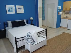 a bedroom with a large bed and a blue wall at Amelie's Apartments in Missolonghi