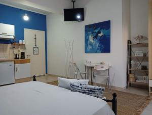 a bedroom with a bed and a table and a kitchen at Amelie's Apartments in Mesolongion +64 photos