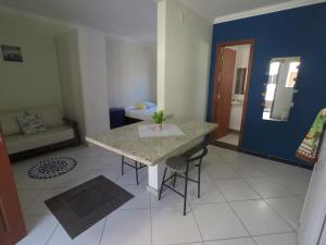 a kitchen with a table and chairs in a room at Barra y Barra Apartamentos in Florianópolis