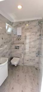 a bathroom with a toilet and a sink and a shower at Motel Lavanda in Avşa Adası