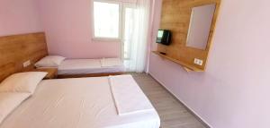 a small room with two beds and a mirror at Motel Lavanda in Avsa Adasi