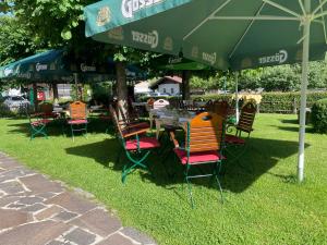 a table and chairs under an umbrella in the grass at Hotel Senningerbräu in Bramberg am Wildkogel