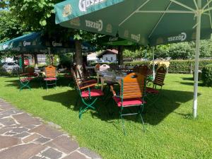 una mesa y sillas bajo una sombrilla en la hierba en Hotel Senningerbräu, en Bramberg am Wildkogel