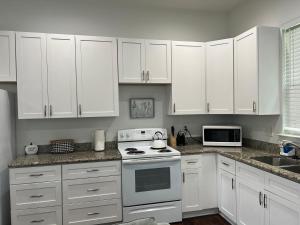 a white kitchen with white cabinets and a stove at New Orleans Home Sweet Home in New Orleans
