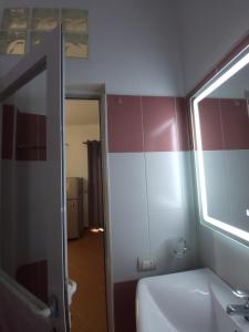 Nuovo Sun Golem في غوليم: حمام مع حوض أبيض ومرآة