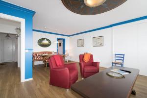 a living room with red chairs and a table at Lord Nelson in Hörnum
