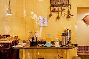 a kitchen with a table with a counter top with some food at Pousada Y-Goá in Bertioga
