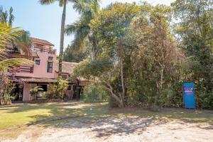a house with a palm tree in the yard at Pousada Y-Goá in Bertioga