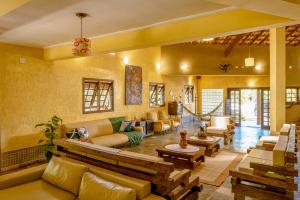 a large living room with couches and tables and chairs at Pousada Y-Goá in Bertioga