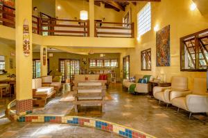 a lobby with couches and tables in a building at Pousada Y-Goá in Bertioga