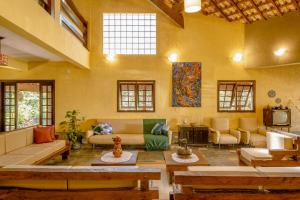 a large living room with couches and a tv at Pousada Y-Goá in Bertioga