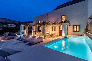 a villa with a swimming pool at night at Canava Villas #1 in Santorini Private Pool in Emporio Santorini