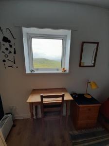 a room with a table and a window and a desk at Gunn Croft in Balallan