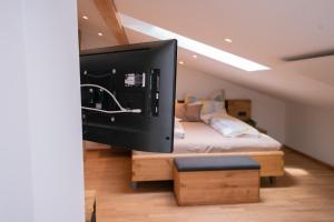 uma televisão de ecrã plano num quarto com uma cama em "Haus am Illufer" Ihr Smart-Alpin-Home in Bludenz em Bludenz